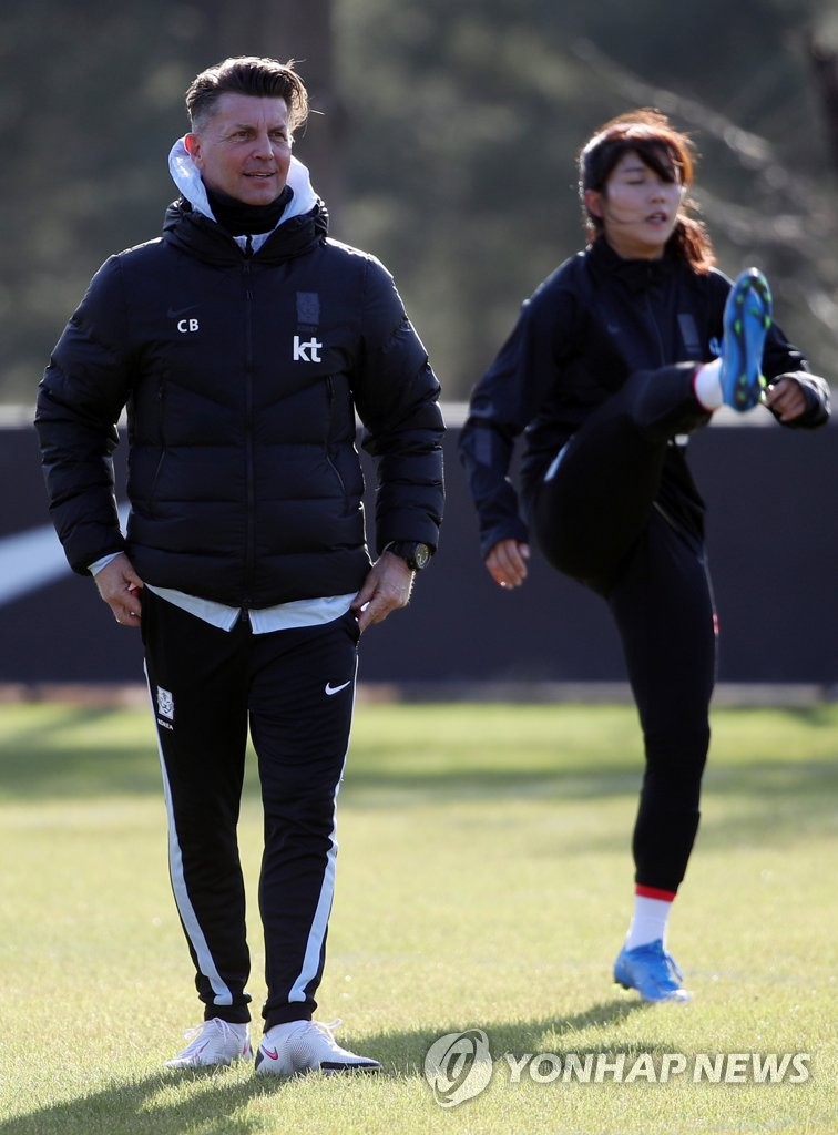 In this file photo from March 22, 2021, Colin Bell (L), head coach of the South Korean women&apos;s national football team, watches his players during practice at the National Football Center in Paju, Gyeonggi Province, in preparation for Olympic qualifying playoff matches against China. (Yonhap)
