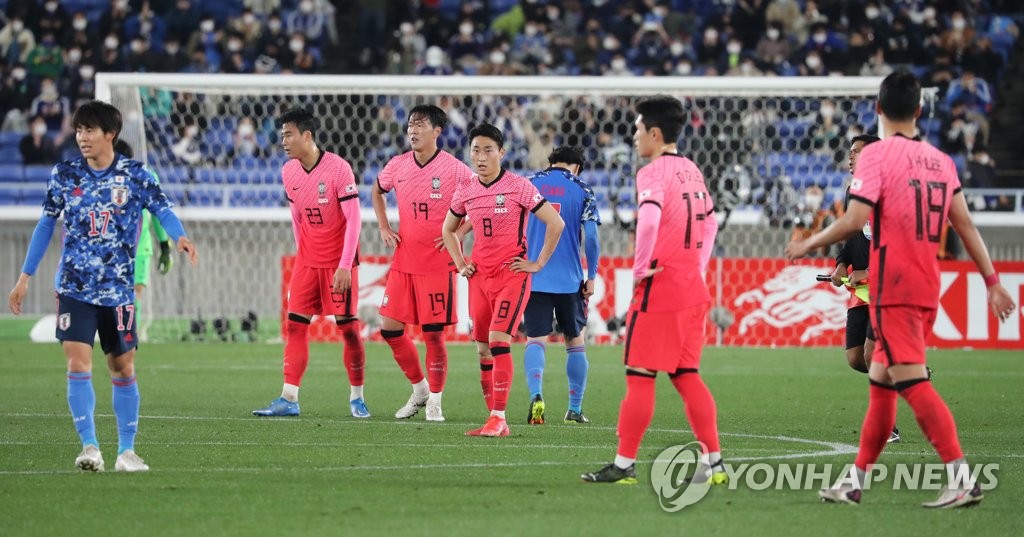 South Korean players (in red) react to their 3-0 loss to Japan in a men's football friendly match at Nissan Stadium in Yokohama, Japan, on March 25, 2021. (Yonhap)