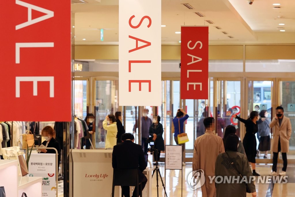 Des personnes visitent le grand magasin Lotte du centre de Séoul, durant les soldes, le lund 5 avril 2021. 