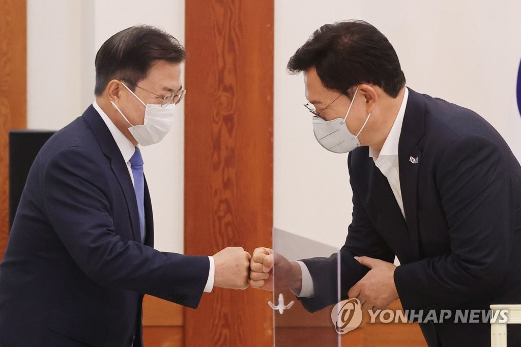 President Moon Jae-in (L) bumps fists with Song Young-gil, head of the Democratic Party, at Cheong Wa Dae in Seoul on May 14, 2021. (Yonhap)