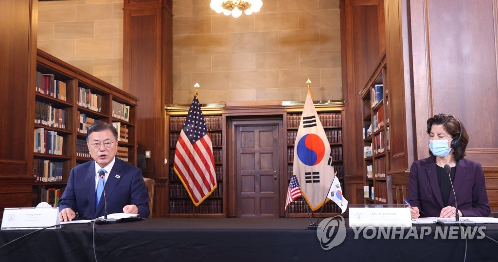 South Korean President Moon Jae-in (L), alongside U.S. Commerce Secretary Gina Raimondo, attends a roundtable meeting with South Korean and U.S. business leaders at the U.S. Department of Commerce in Washington on May 21, 2021. (Yonhap)