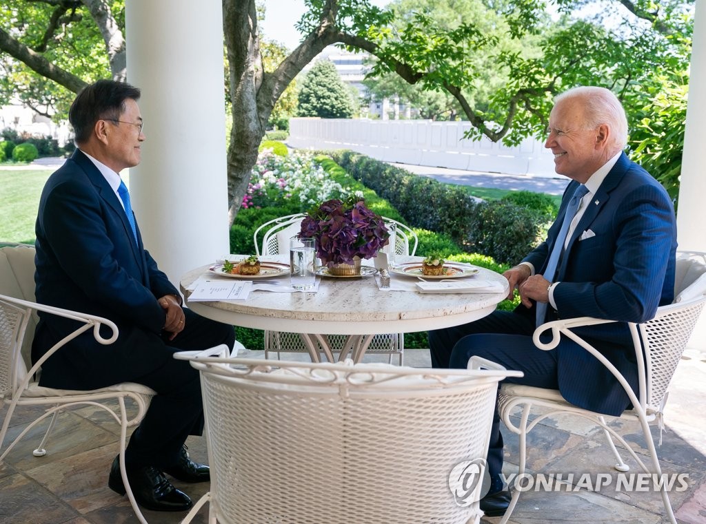 South Korean President Moon Jae-in (L) converses with his U.S. counterpart Joe Biden over lunch at the White House on May 21, 2021, in a photo provided by Cheong Wa Dae. (PHOTO NOT FOR SALE) (Yonhap)
