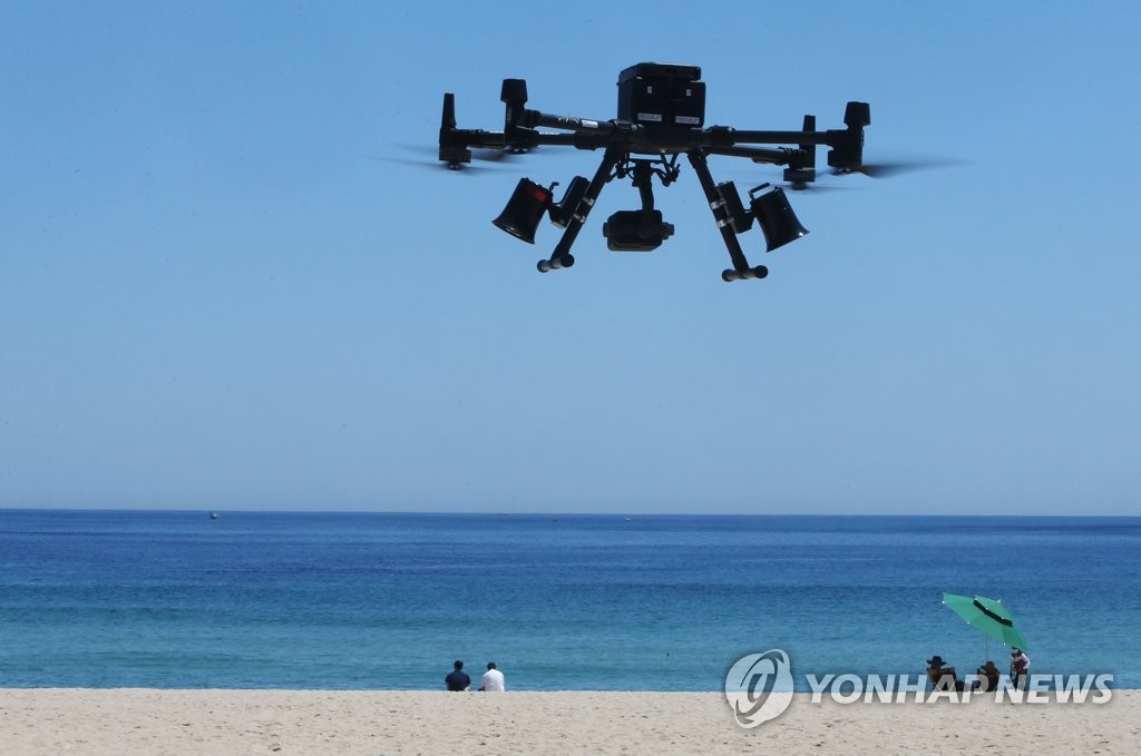 A drone equipped with thermal image cameras flies over a beach in Gangneung on the eastern coast to detect people with high temperatures on June 4, 2021, as part of antivirus measures. (Yonhap)