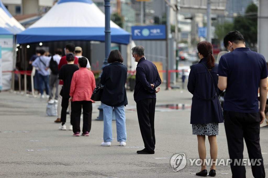 Des citoyens font la queue avant de se soumettre à un test de dépistage du Covid-19 dans une clinique provisoire à Séoul, le 9 juin 2021.