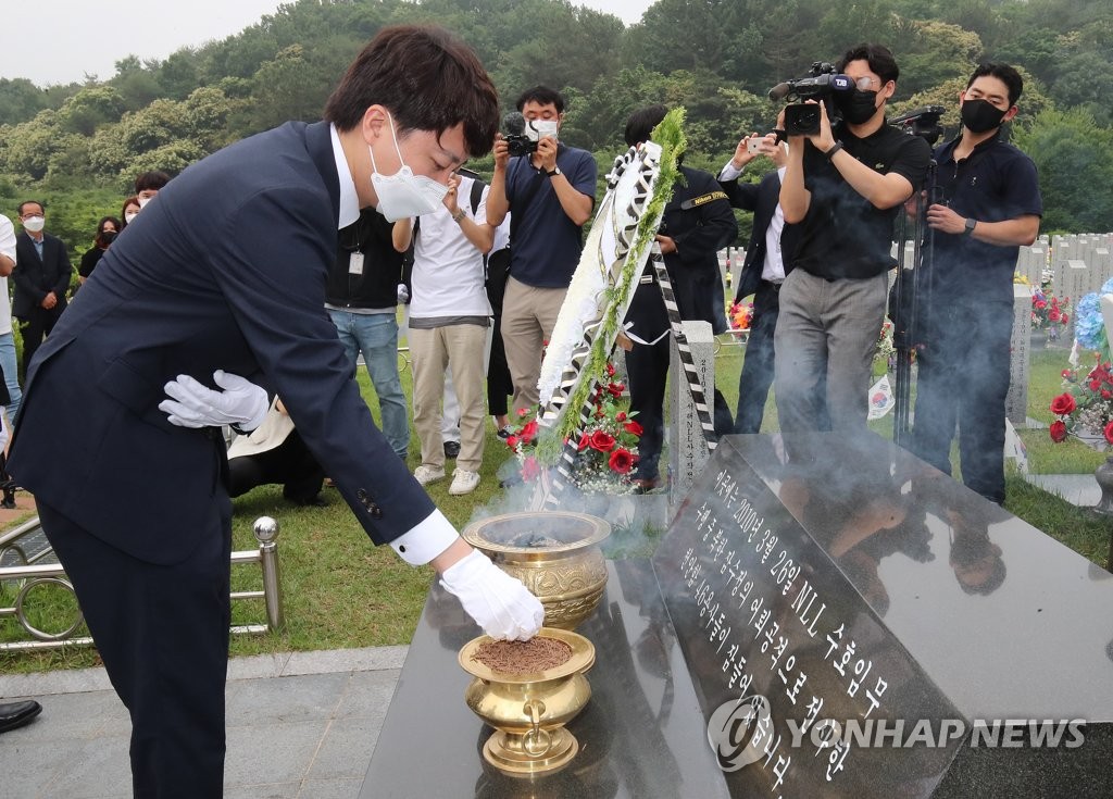 Lee Jun-seok, new chairman of the main opposition People Power Party, burns incense in front of the tombs of South Korean sailors of the sunken naval ship Cheonan during a visit to the National Cemetery in Daejeon, 164 kilometers south of Seoul, on June 14, 2021. (Yonhap)