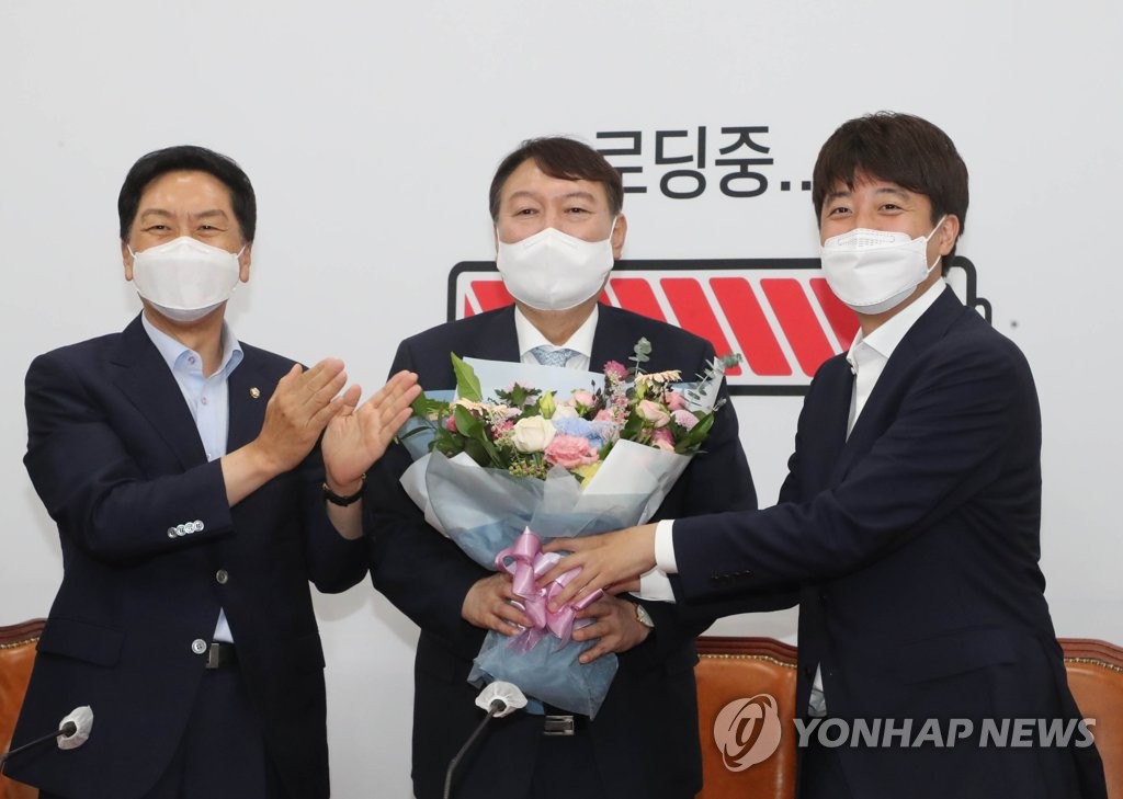 Former Prosecutor General Yoon Seok-youl (C), a front-running presidential aspirant who has joined the main opposition People Power Party, is greeted by Chairman Lee Jun-seok (R) and floor leader Rep. Kim Gi-hyeon during a welcome reception held at the National Assembly in Seoul on Aug. 2, 2021. (Yonhap) 