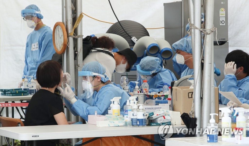 Medical workers carry out COVID-19 tests at a makeshift clinic in western Seoul on Aug. 2, 2021. (Yonhap)