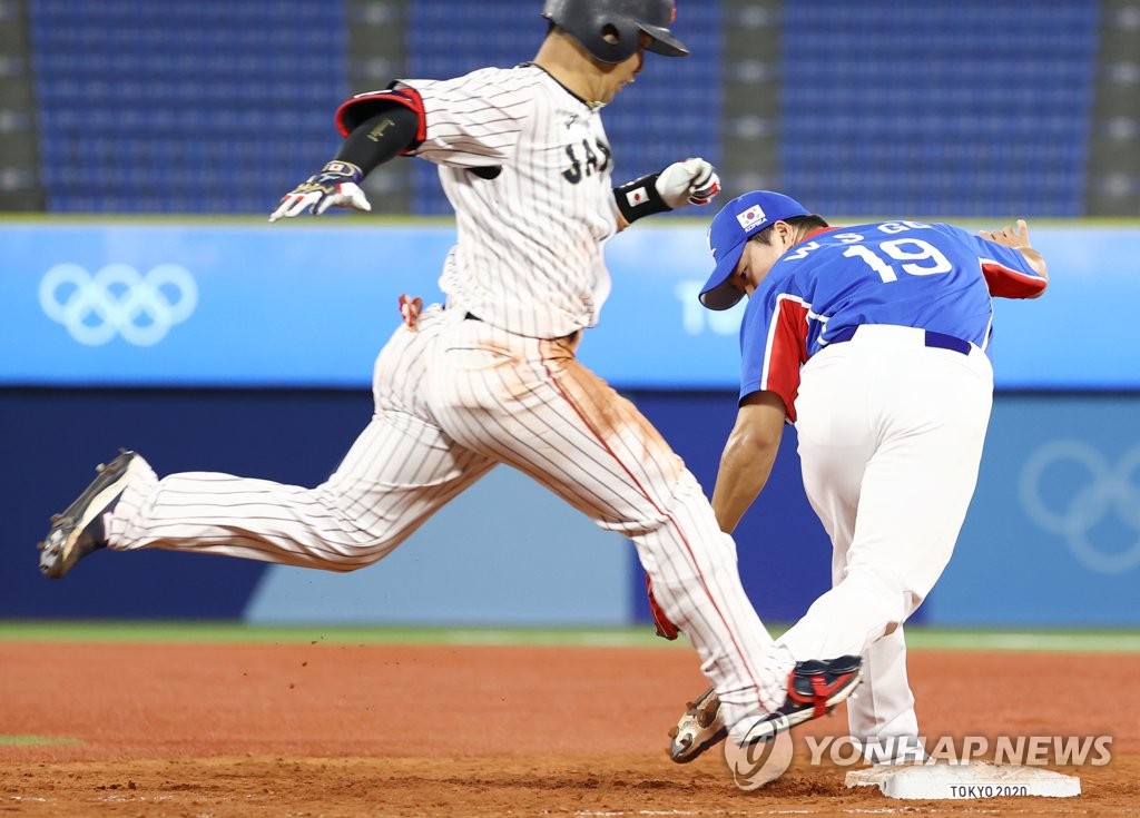 Go Woo-suk of South Korea (R) misses the first base bag as Konsuke Kondoh reaches safely during the bottom of the eighth inning in the semifinals of the Tokyo Olympic baseball tournament at Yokohama Stadium in Yokohama, Japan, on Aug. 4, 2021. (Yonhap)