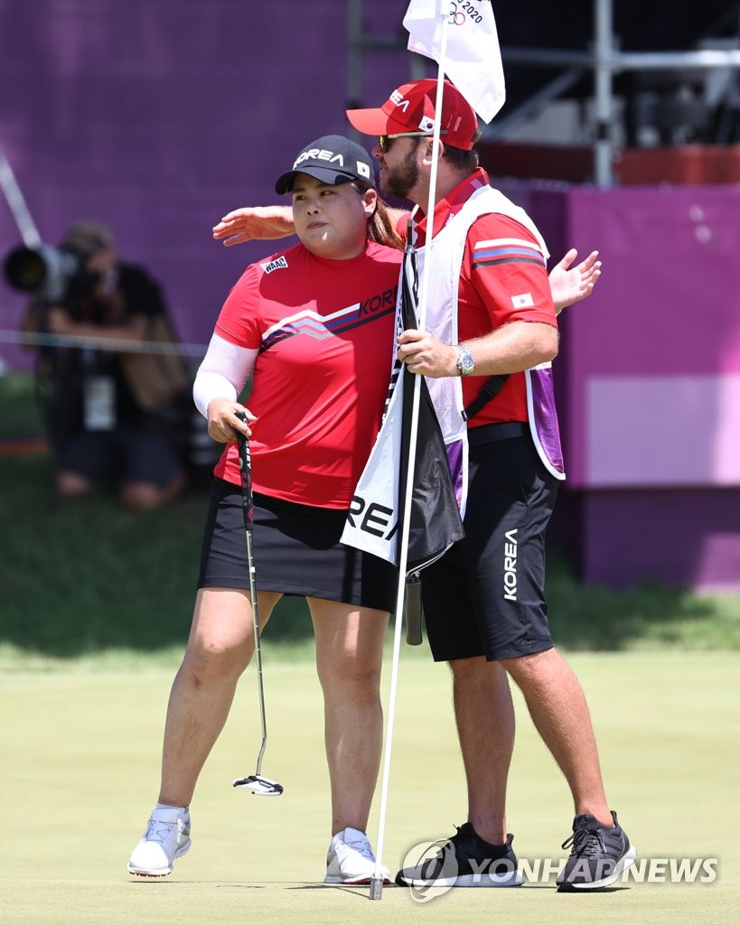 Park In-bee of South Korea (L) embraces her caddie, Brad Beecher, after completing the third round of the Tokyo Olympic women's golf tournament at Kasumigaseki Country Club in Saitama, Japan, on Aug. 6, 2021. (Yonhap)