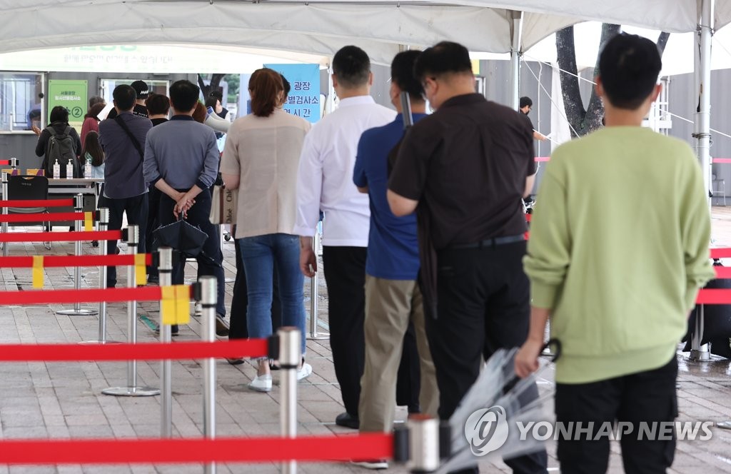 People wait to take a coronavirus test at a makeshift clinic near Seoul Station in central Seoul on Oct. 9, 2021. (Yonhap)