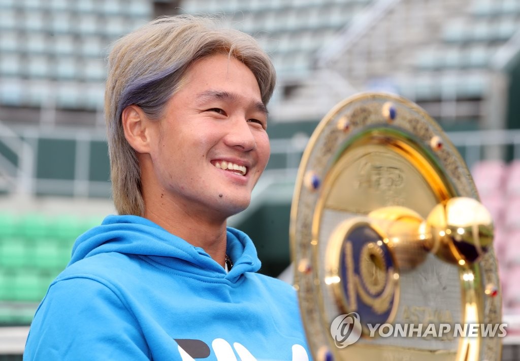 South Korean tennis player Kwon Soon-woo smiles during a press conference at Olympic Park Tennis Center in Seoul on Oct. 12, 2021, while seated next to his trophy from the Astana Open on the ATP Tour. (Yonhap)