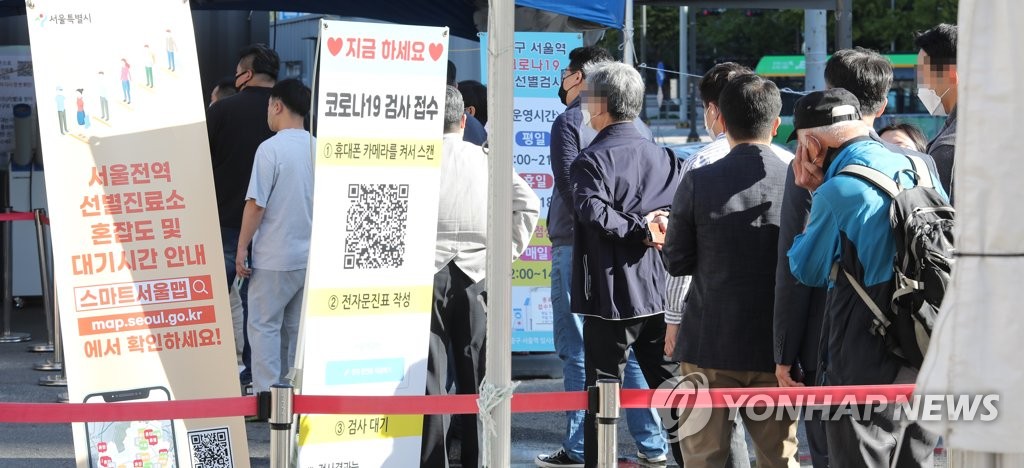ソウル駅前にある新型コロナウイルスの臨時検査所に市民の長い列ができている＝１３日、ソウル（聯合ニュース）