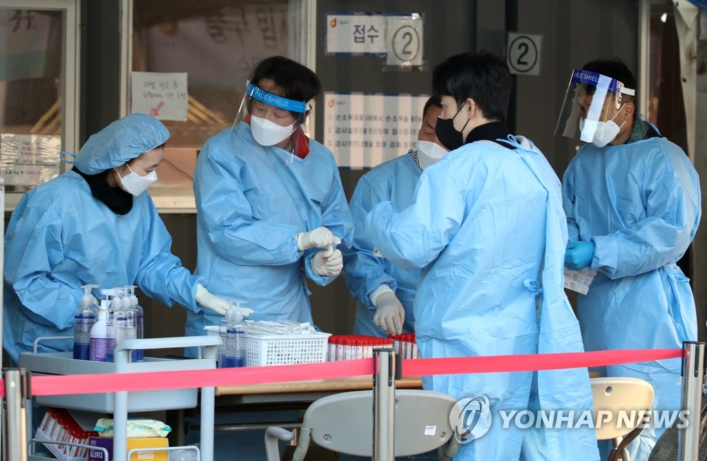 Health workers make preparations to conduct COVID-19 tests at a testing site near Seoul Station in central Seoul on Oct. 24, 2021. (Yonhap)