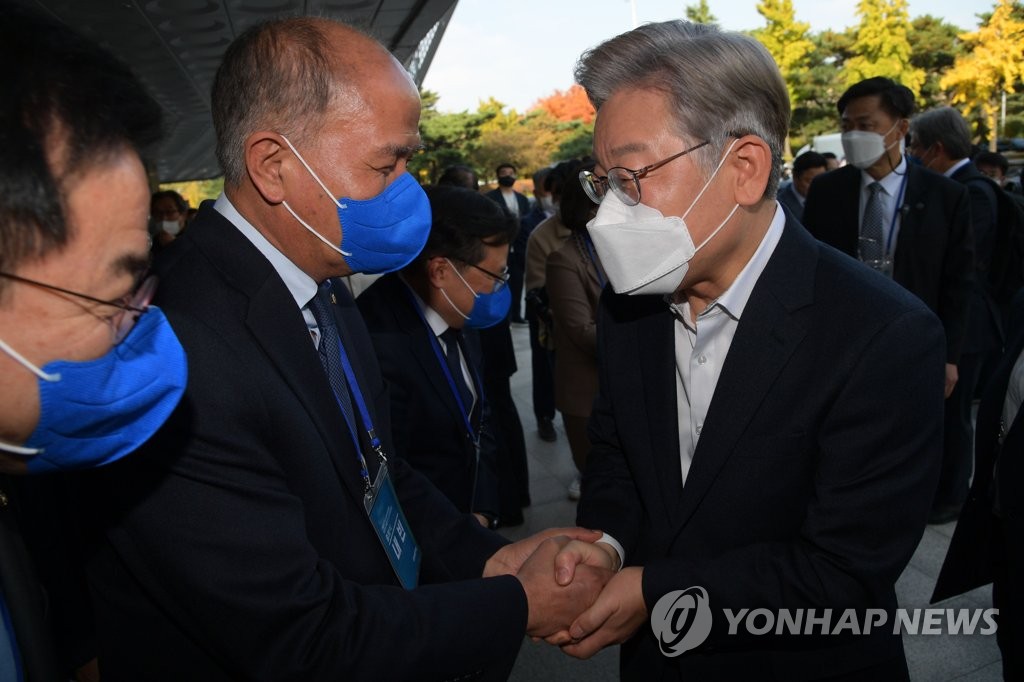 Lee Jae-myung (R), the presidential nominee of the ruling Democratic Party, shakes hands with party officials after attending the party's launching of its presidential election committee in Seoul on Nov. 2, 2021. (Pool photo) (Yonhap)