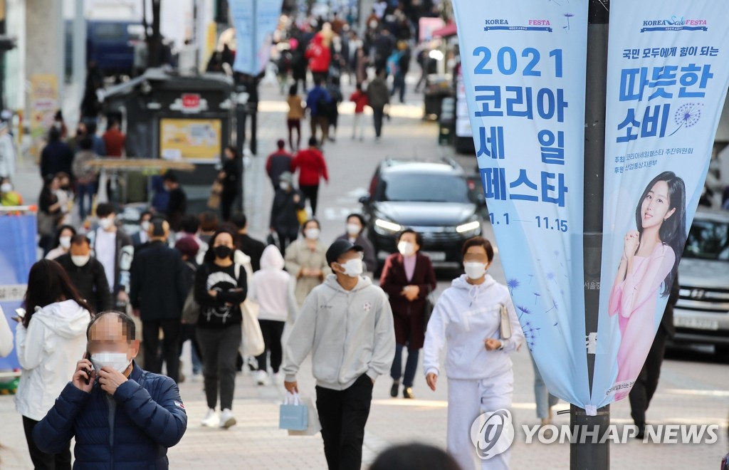 This photo, taken Nov. 7, 2021, shows people walking on the street of the shopping district of Myeongdong in Seoul as a state-led sales festival is underway. (Yonhap)