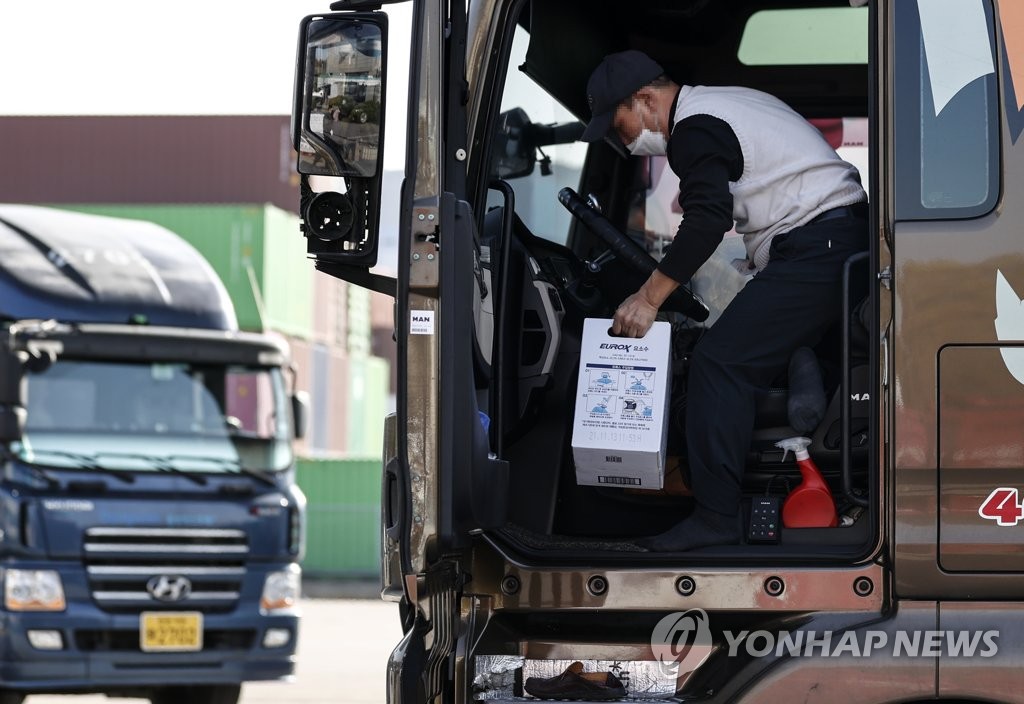 A truck driver loads a box of urea solution, which is needed in diesel vehicles to cut emissions, at a gas station in Uiwang, south of Seoul, on Nov. 16, 2021. (Yonhap)