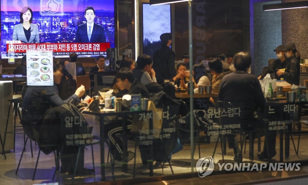 A restaurant in downtown Seoul shows a TV screen airing a news report on the first cases of the omicron COVID-19 variant confirmed in South Korea on Dec. 1, 2021. (Yonhap) 