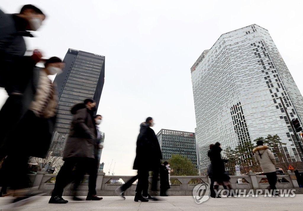 This photo, taken Dec. 2, 2021, shows salaried workers crossing a road for lunch meetings in downtown Seoul amid concerns over the spread of a new virus variant. (Yonhap)