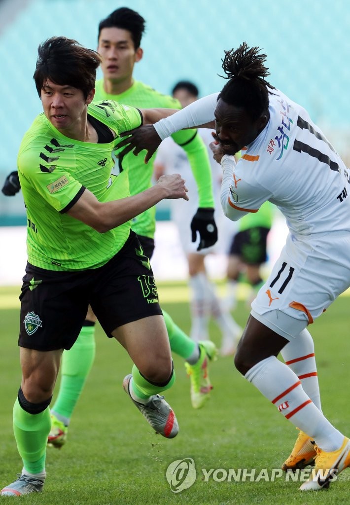 Ku Ja-ryong of Jeonbuk Hyundai FC (L) and Gerso Fernandes of Jeju United battle for the ball during the clubs' K League 1 match at Jeonju World Cup Stadium in Jeonju, some 240 kilometers south of Seoul, on Dec. 5, 2021. (Yonhap)