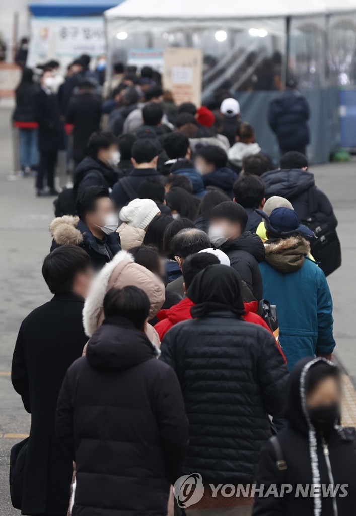 In this file photo, people stand in line to take coronavirus tests at a screening clinic in front of Seoul Station on Dec. 24, 2021. South Korea's new coronavirus cases fell below 7,000 for the second day in a row on the back of antivirus restrictions, but critical cases surged to a record high of 1,084. (Yonhap)