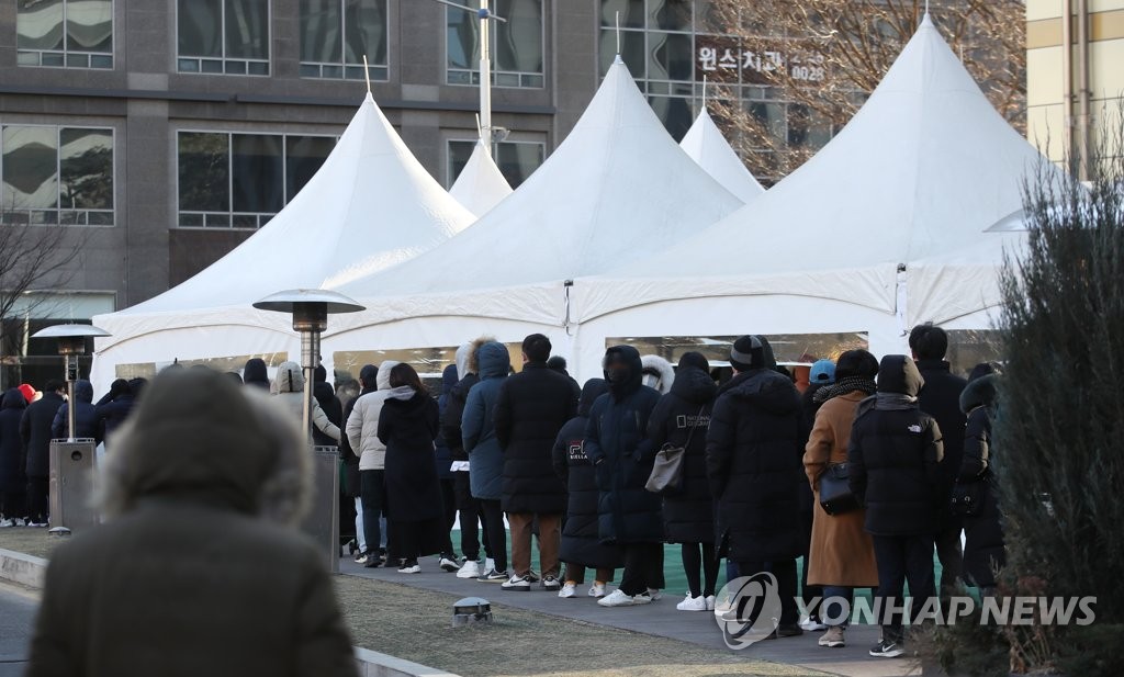 Las personas esperan en fila para someterse a las pruebas del nuevo coronavirus, el 26 de diciembre de 2021, en una clínica provisional, en el distrito de Songpa, en el sureste de Seúl.