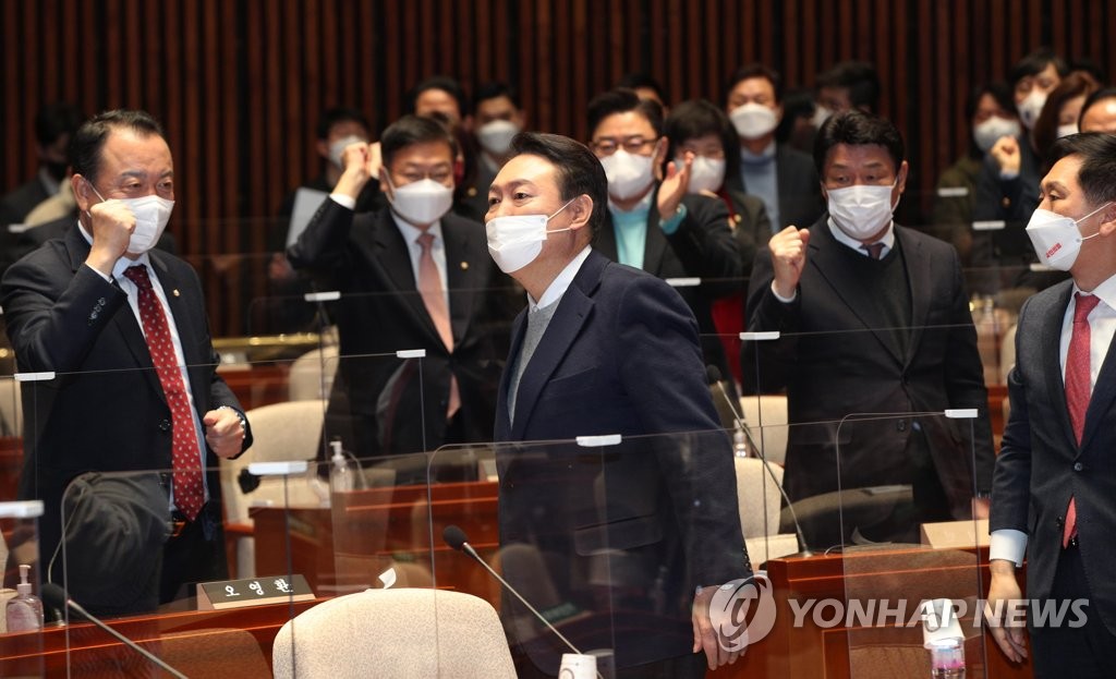 Yoon Suk-yeol (au centre), le candidat présidentiel du Parti du pouvoir du peuple (PPP), retourne à son siège après son discours lors d'une réunion du parti à Séoul, le 6 janvier 2022. (Pool photo)