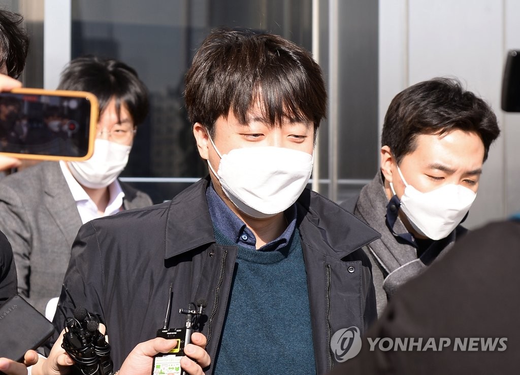 Le chef du Parti du pouvoir du peuple (PPP), Lee Jun-seok, est entouré de journalistes alors qu'il quitte son bureau à Séoul, le 6 janvier 2022. (Pool photo)