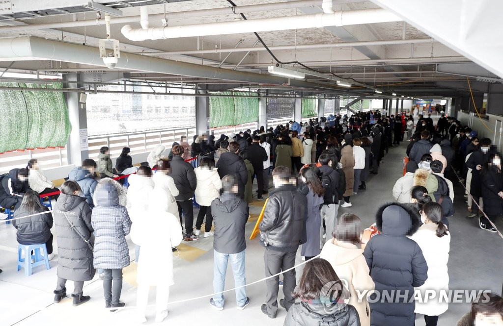 De nombreuses personnes font la queue pour se faire dépister du nouveau coronavirus (Covid-19) au centre provisoire dans l'arrondissement de Buk à Gwangju, le mercredi 12 janvier 2022. (Photo fournie par la mairie de l'arrondissement de Buk. Revente et archivage interdits) 