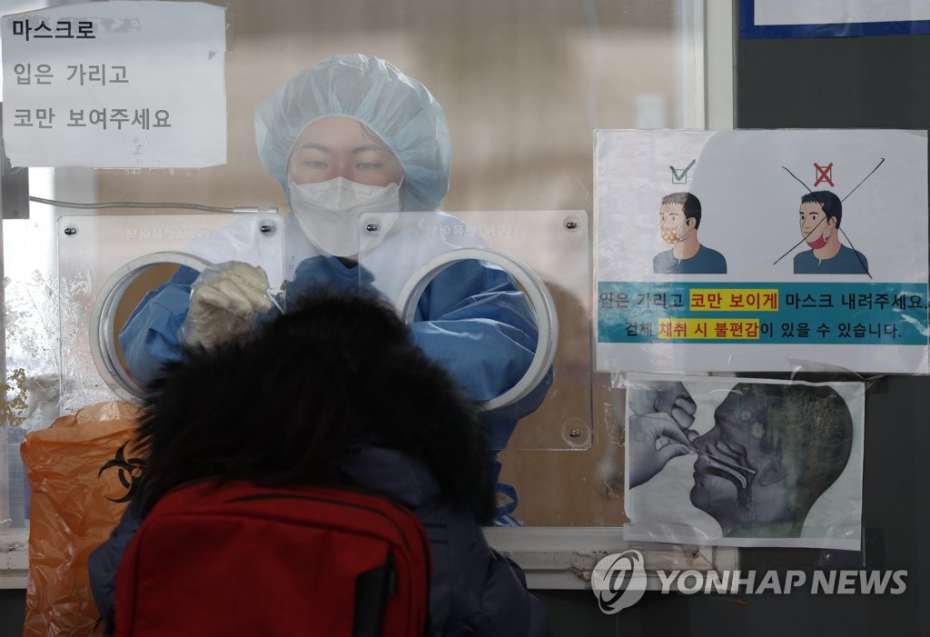 Une membre du personnel médical effectue un test de dépistage pour le nouveau coronavirus (Covid-19) le lundi 24 janvier 2022, dans le centre installé sur la place de la gare de Séoul. 