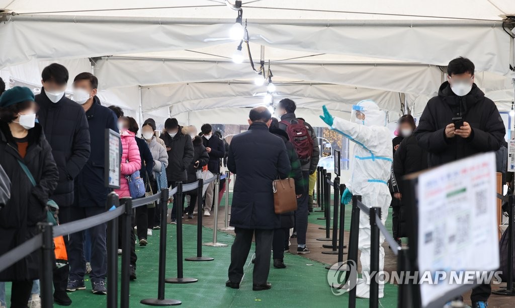 El 25 de enero de 2022, una estación de exámenes de COVID-19 en el distrito de Songpa, en el este de Seúl, está abarrotada de personas que aguardan en fila para hacerse las pruebas de diagnóstico.