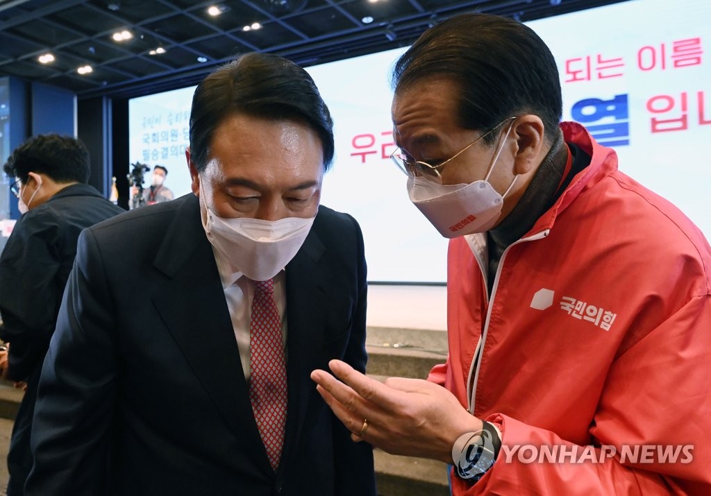 In this file photo, Yoon Suk-yeol (L), the presidential candidate of the main opposition People Power Party, speaks with his campaign chief Rep. Kwon Young-se at a party event in Seoul on Jan. 26, 2022. (Pool photo) (Yonhap)