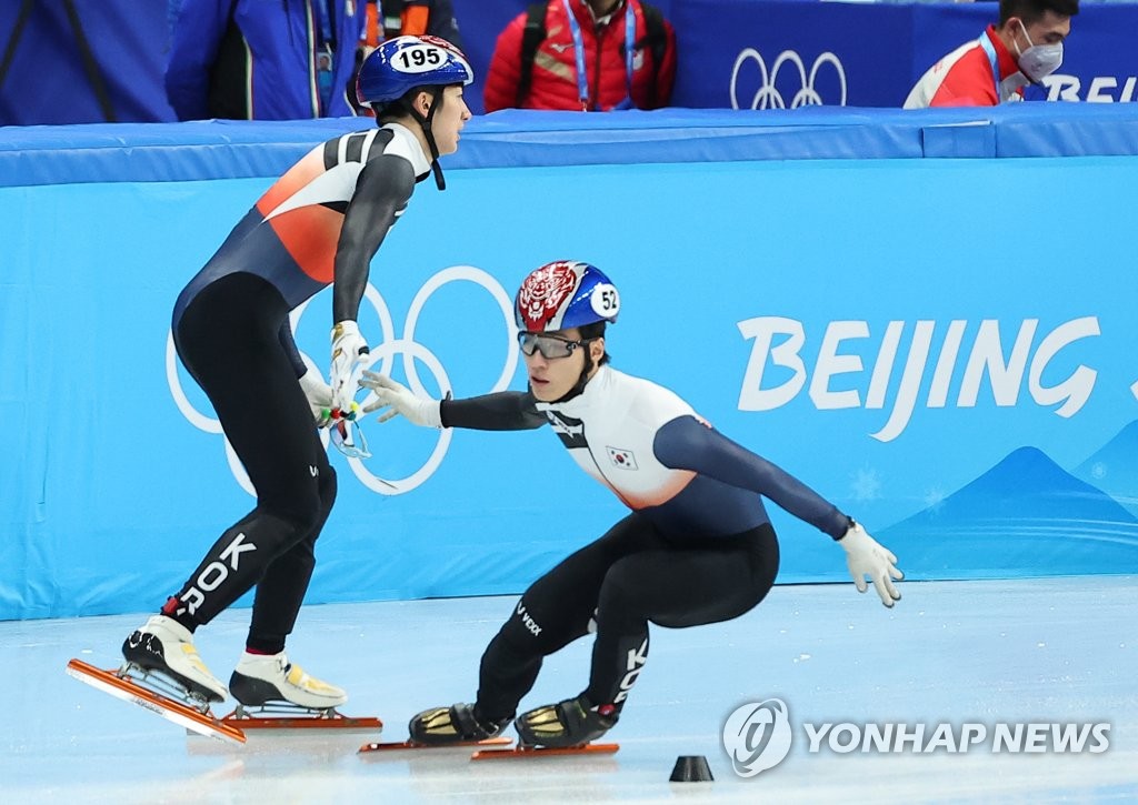 Hwang Dae-heon of South Korea (R) makes an exchange with teammate Park Jang-hyuk during the quarterfinals of the mixed team relay in short track speed skating at the Beijing Winter Olympics at Capital Indoor Stadium in Beijing on Feb. 5, 2022. (Yonhap)