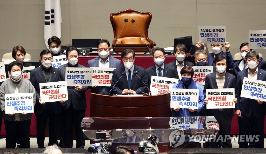 Lawmakers of the ruling Democratic Party call for the passage of a government-proposed extra budget aimed at supporting small businesses hit by COVID-19 during a news conference at the National Assembly in Seoul on Feb. 18, 2022. (Yonhap)