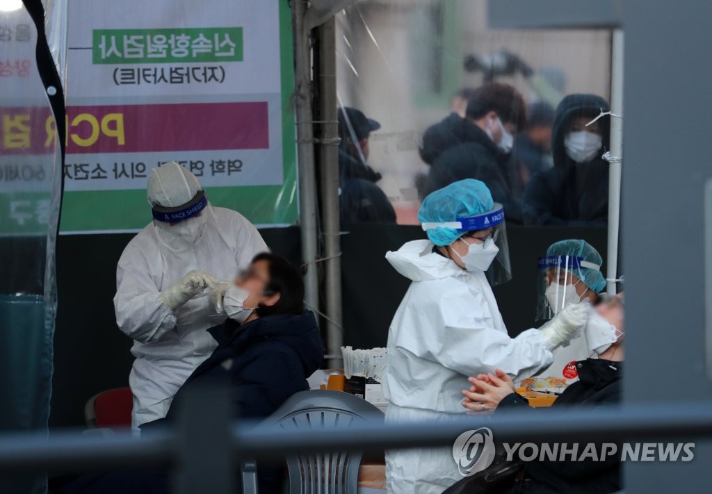 Des personnes passent un test de dépistage du nouveau coronavirus (Covid-19) dans le centre installé sur la place de la gare de Séoul le jeudi 24 février 2022. 