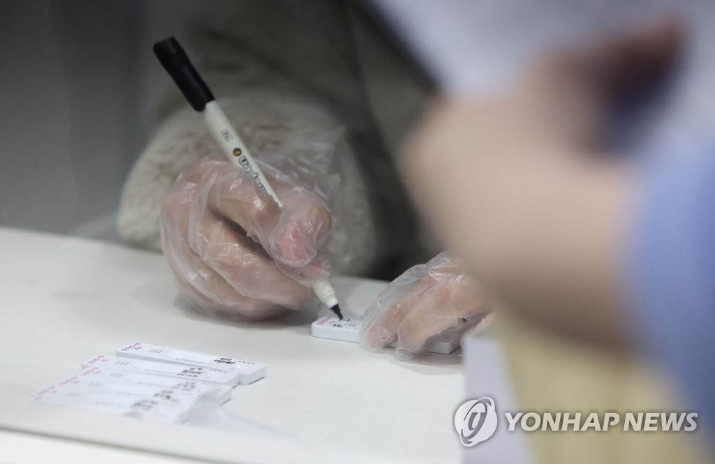 A medical official conducts a COVID-19 test, using a rapid antigen test kit, at a hospital in Seoul on March 11, 2022. (Yonhap)