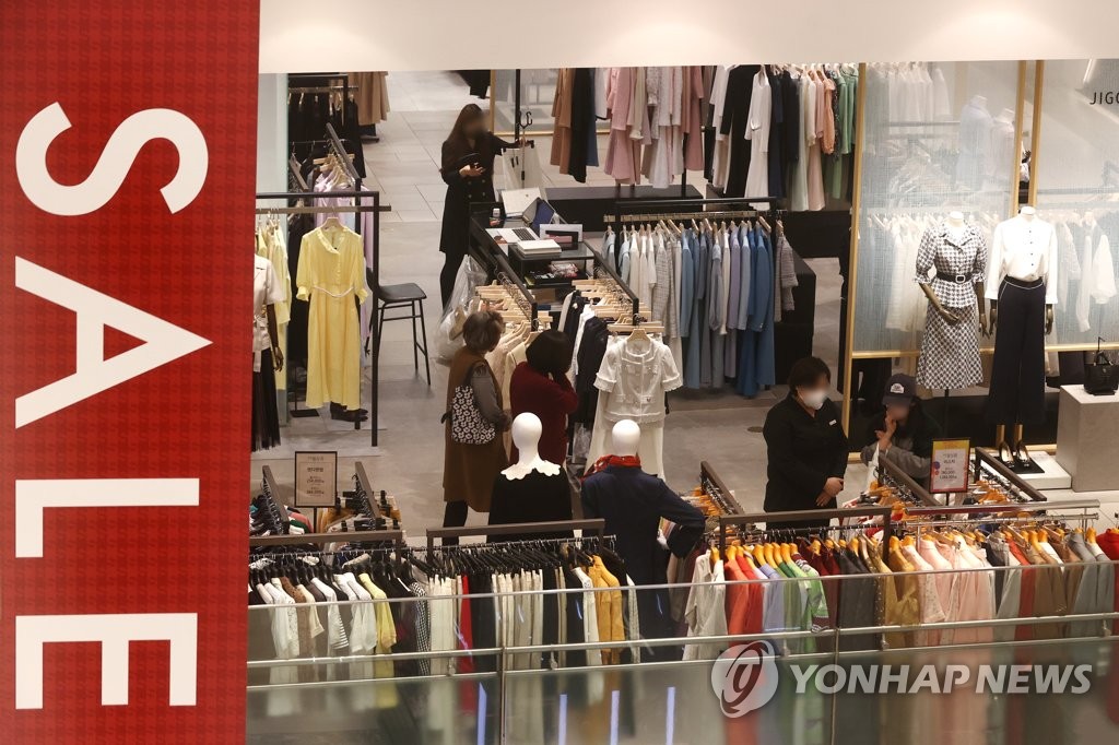 People shop for clothes at a department store in Seoul on April 1, 2022. (Yonhap)