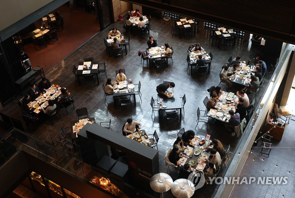 People have lunch at a restaurant in central Seoul amid relaxed virus curbs on April 4, 2022. (Yonhap)