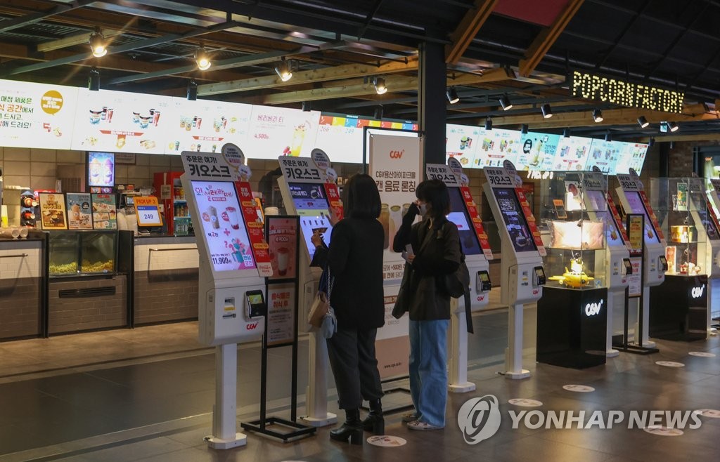 In this file photo taken April 24, 2022, people order snacks at a Seoul theater. (Yonhap)