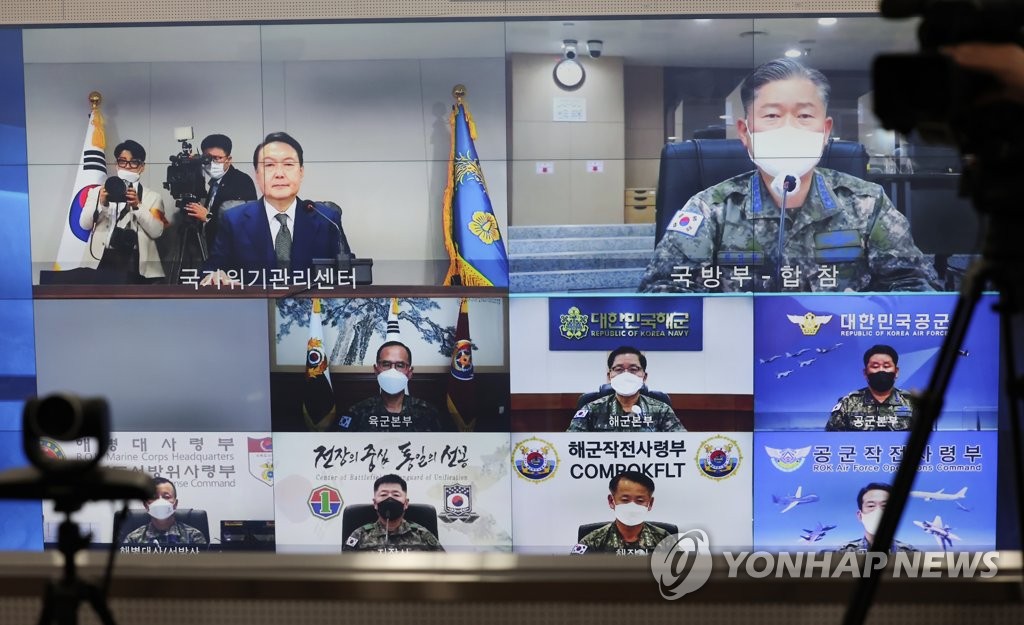 La pantalla muestra al nuevo presidente de Corea del Sur, Yoon Suk-yeol (izda., arriba), recibiendo, como comandante en jefe, un informe del jefe del JCS, el general Won In-choul (dcha., arriba), el 10 de mayo de 2022, en el búnker subterráneo de la nueva oficina presidencial, en Yongsan, Seúl. (Foto proporcionada por la oficina de Yoon. Prohibida su reventa y archivo)