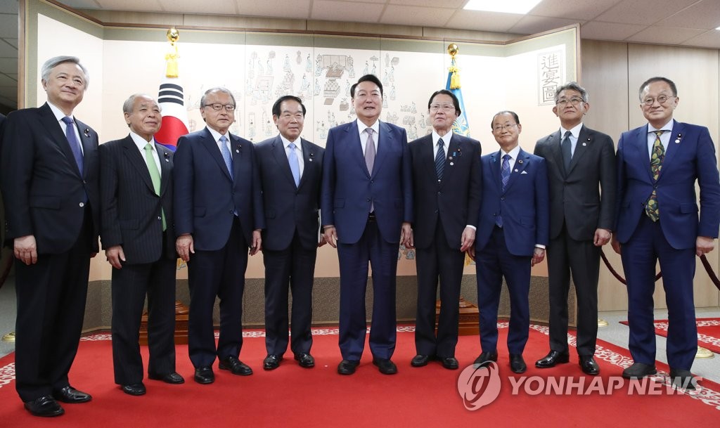 Le président sud-coréen Yoon Suk-yeol (au centre) pose avec un groupe de législateurs japonais, dirigé par Fukushiro Nukaga (4e en partant de la gauche), président de l'Union des parlementaires nippo-coréens, au bureau présidentiel à Séoul le 11 mai 2022. La délégation a assisté à la cérémonie d'investiture de Yoon le jour précédent. (Yonhap)