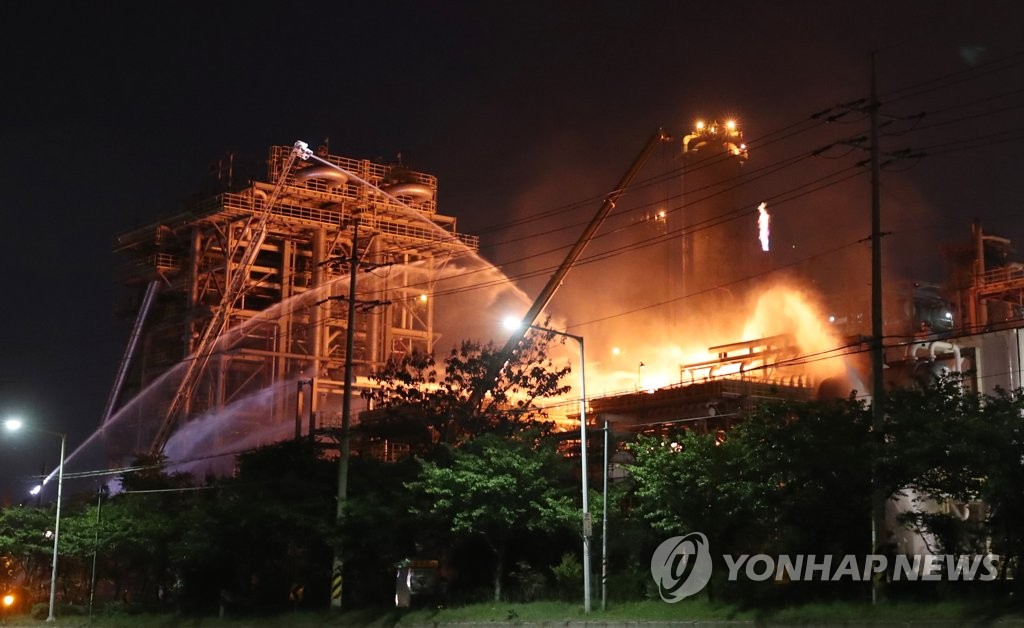 Firefighters work to put out a fire at a refinery run by S-Oil Corp. on May 20, 2022, following an explosion that killed one and injured nine others. (Yonhap)