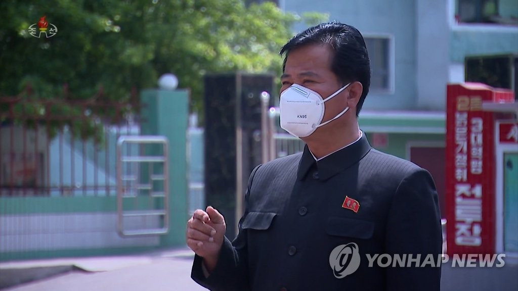 A North Korean man wearing a face mask believed to be made in China walks on a street amid a surge in suspected coronavirus cases, in this photo captured from the North's official Korean Central Television. (For Use Only in the Republic of Korea. No Redistribution) (Yonhap)