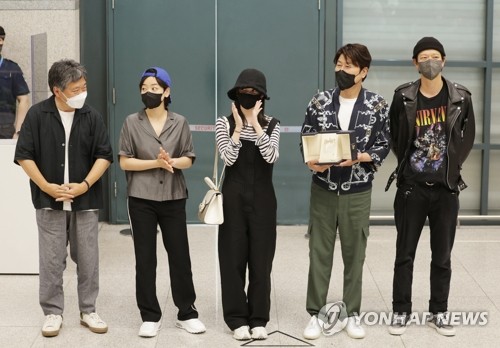 Actor Song Kang-ho (2nd from R), director Hirokazu Kore-eda (1st from L) and other cast members of the film "Broker" pose for a photo after arriving at Incheon International Airport in Incheon, west of Seoul, on May 30, 2022. (Yonhap)