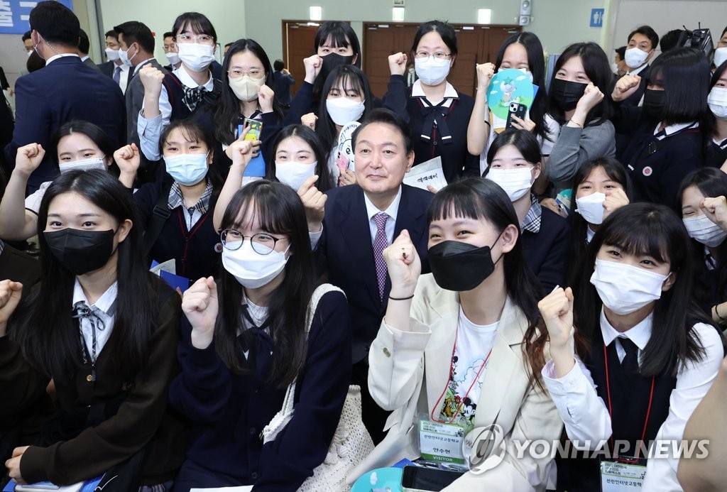 President Yoon Suk-yeol (C, 2nd row) poses with students while visiting an annual job fair for high school graduates at an exhibition center in Goyang, northwest of Seoul, on June 2, 2022. (Yonhap)