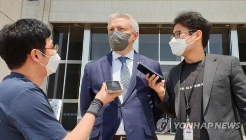 El embajador de Ucrania ante Corea del Sur, Dmytro Ponomarenko (centro), habla con los reporteros tras su reunión con Lee Jun-seok, jefe del gobernante Partido del Poder del Pueblo, el 3 de junio de 2022, en la Asamblea Nacional, en Seúl.