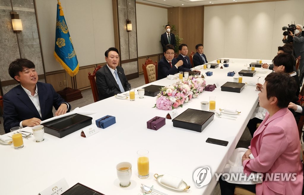El presidente surcoreano, Yoon Suk-yeol (segundo por la izda., fondo), habla con el jefe del gobernante Partido del Poder del Pueblo (PPP), Lee Jun-seok (izda., fondo), durante un almuerzo de trabajo, celebrado, el 10 de junio de 2022, en la oficina presidencial, en Seúl, junto con otros miembros del partido.