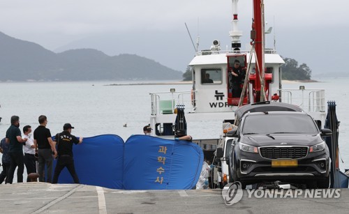Police obstruct the view of rescuers pulling bodies out of a car found in the sea off the southwestern island of Wando on June 29, 2022. (Yonhap)