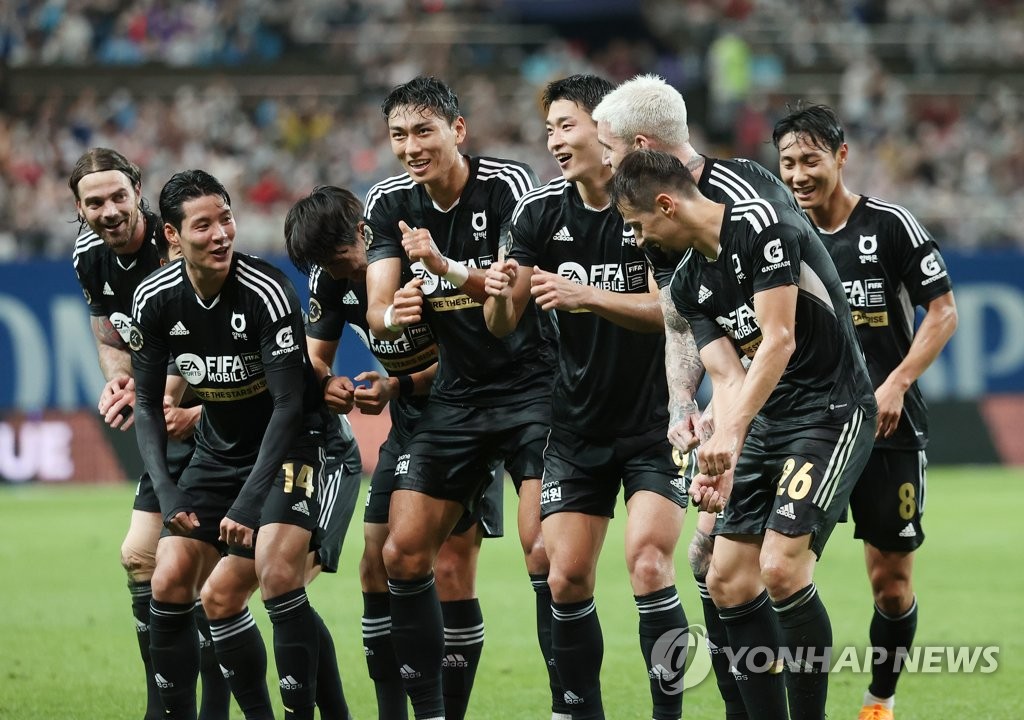 Les membres de l'équipe K League célèbrent un but de Cho Gue-sung (3e à partir de la droite) contre Tottenham Hotspur lors du match d'exhibition des équipes au Seoul World Cup Stadium, le 13 juillet 2022.