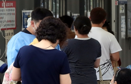 Des personnes attendent de se faire dépister pour le nouveau coronavirus (Covid-19) au centre de dépistage installé près de la station de métro Juan à Incheon, le vendredi 15 juillet 2022. 