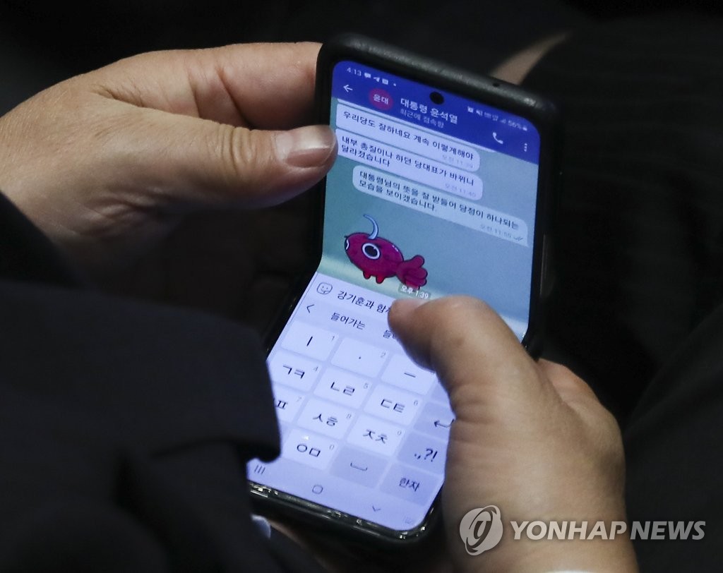 Rep. Kweon Seong-dong, acting chair and floor leader of the People Power Party, exchanges a text message during an interpellation session at the National Assembly on July 26, 2022. (Pool photo) (Yonhap)